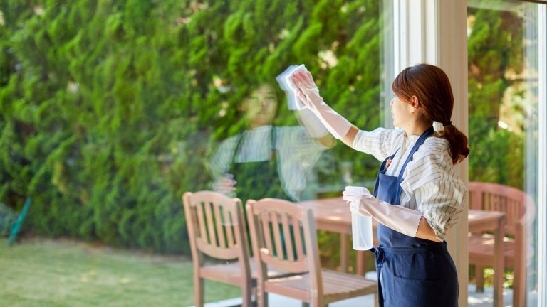Image of woman cleaning a window